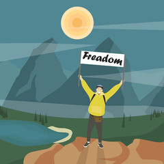 A traveler in the mountains holding a sign "Freedom". Summer active pastime. Active kind of sport. Adventures. Freedom. Mountains, lake, trees and sun. A man in tourist clothes with a backpack.