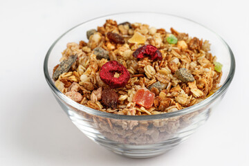 Muesli in a glass plate, isolated on a white background. Healthy breakfast.