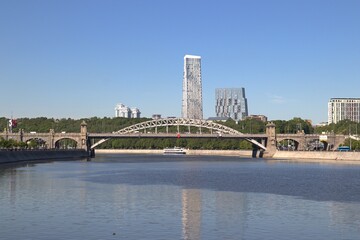 Moscow River, panoramic view of the automobile bridge. On the background of a high-rise building and a blue sky.