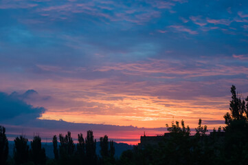 Landscape with dramatic light - beautiful golden sunset with saturated sky and clouds.