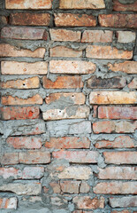 Old brick wall texture. The wall, made of old red bricks, darkened by old age. Ancient vintage background. Brick wall