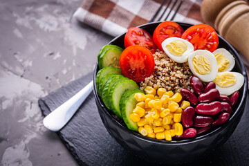 bowl of healthy quinoa with vegetables on a dark rustic background