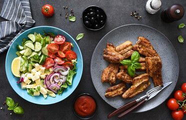 Picnic. Greek salad, sauce and grilled ribs on the kitchen table.
