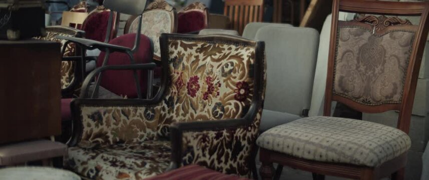 Retro old-fashioned furniture for sale on a flea marketplace outdoors. Slow motion. 