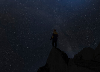 silhouette of a person standing on top of mountain and watch the sky galaxy. elements of this image furnished by nasa
