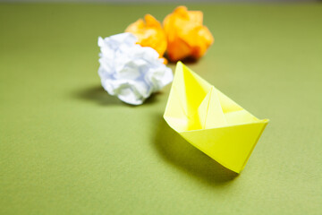 yellow paper boats and reams of paper