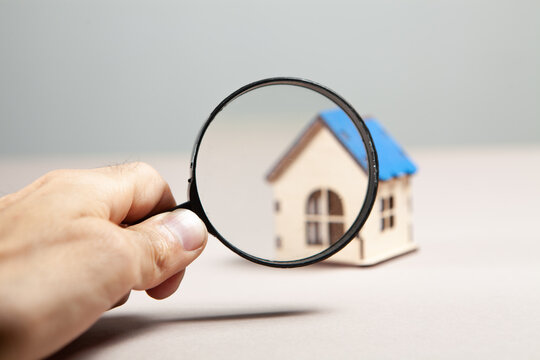 magnifier and house on a pink background.