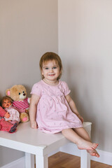 One and a half year old girl playing with a teddy bear. Taking care of children	