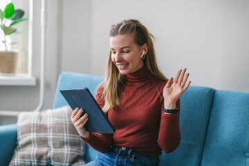 The girl communicates with family and friends by video call on the tablet. Chat and keep in touch without leaving home