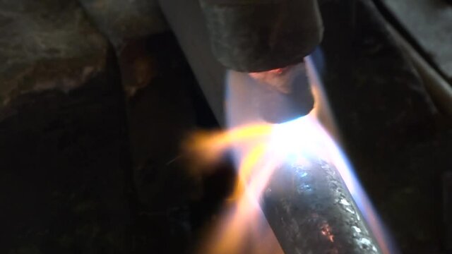 Close-up of autogenous welding of copper pipe, urgent repair welding of malfunctional home central heating system