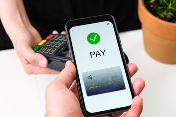 Customer paying bill using mobile phone application and POS terminal machine. Wallet in smartphone