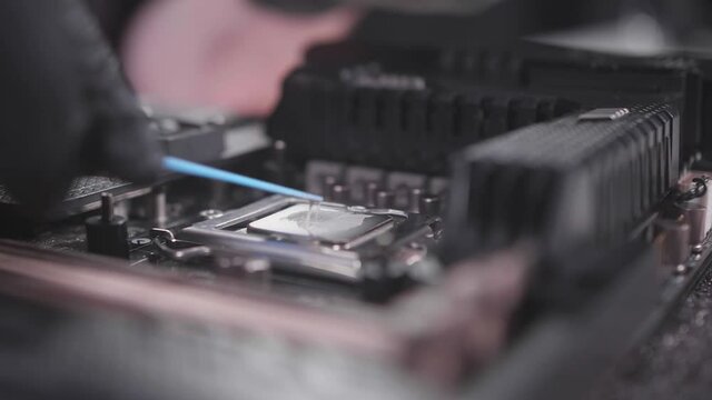 Technology of replacing thermo paste on the CPU close shot. Upgrade of computer components. Service for the repair and replacement of the computer motherboard.