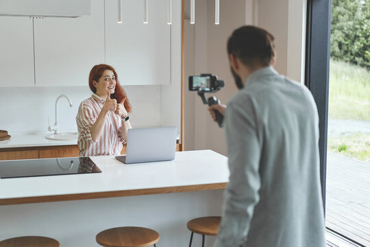 Successful millennial vloggers couple recording seminar at smartphone and steadycam