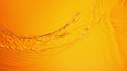 Super Slow Motion of Orange Water Surface at 1000fps. Top Down View. - Powered by Adobe