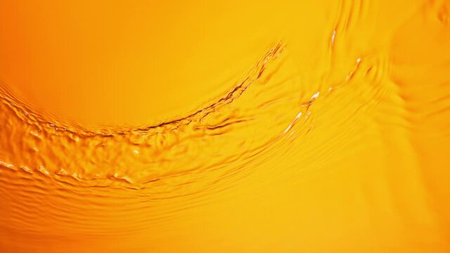 Super Slow Motion of Orange Water Surface at 1000fps. Top Down View. - Powered by Adobe