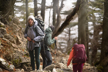 Young stylish travelers discover and enjoy the nature, walk the trail among the mountains and...