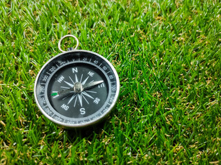 Compass on grass background. Travel concept.Compass with fresh green grass and copy space.
