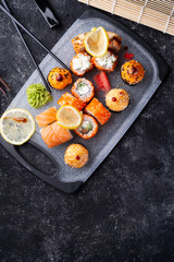 sushi roll set served at grey tray at black table. flat lay. close up
