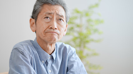 悩む高齢の男性