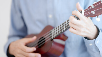 ウクレレを弾く高齢の男性