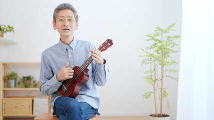 ウクレレを弾く高齢の男性