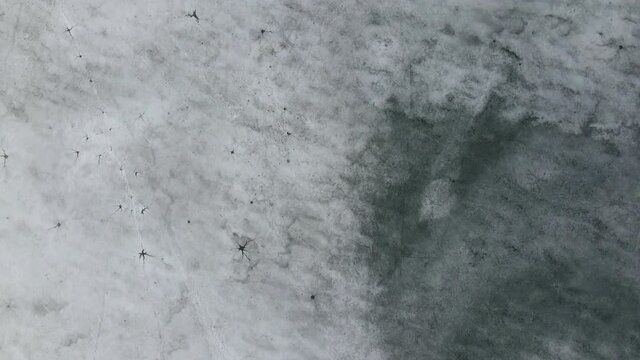 Drone view on ice on the lake or river. Cracking and melting ice on water.
