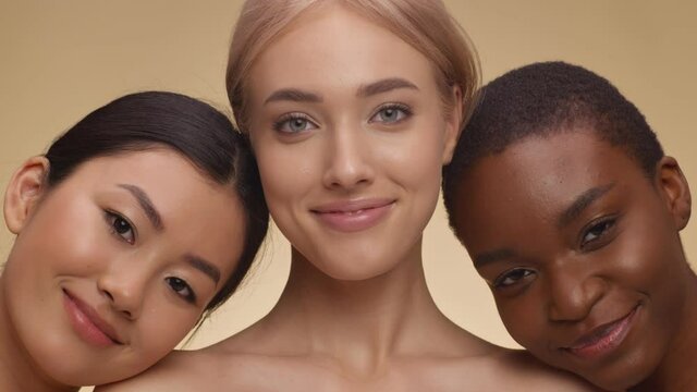 Variety of beauty. Close up portrait of asian, caucasian and african american ladies embracing and smiling to camera
