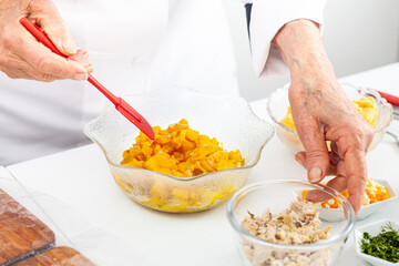 Senior woman preparing the filling for a traditional dish from el Valle del Cauca in Colombia called empanada