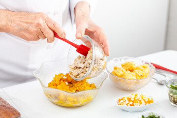 Senior woman preparing the filling for a traditional dish from el Valle del Cauca in Colombia called empanada