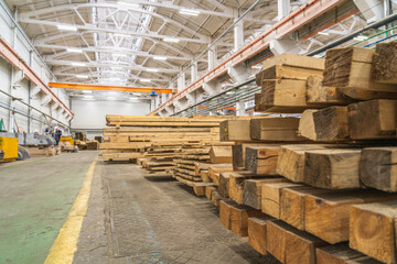 Inside huge factory workshop interior with stacks of wood for making molds.