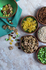 vista cenital de cuencos con frutos secos sobre fondo abstracto gris y blanco