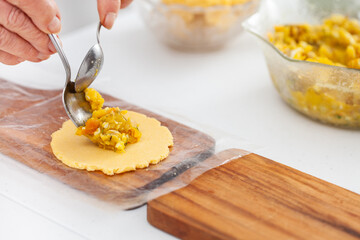 Senior woman filling an empanada a traditional dish from el Valle del Cauca in Colombia