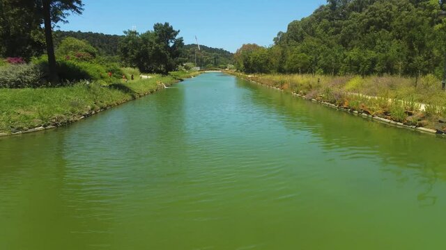 Aerial view low over green water in the Nautical Activities Track, in Lisbon