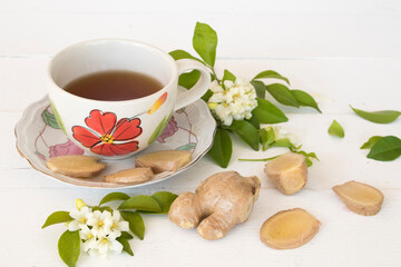 hot ginger water herbal healthy drinks health care for cough sore with flowers arrangement flat lay style on background wooden white