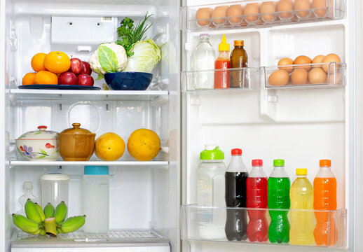 Look into the refrigerator with the lid open a lots of fresh food and drinks inside.