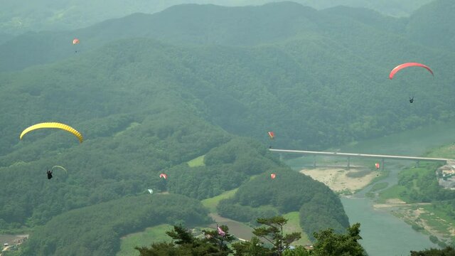 People Tandem paragliding over mountains in Danyang South Korea top view