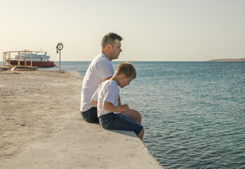 Fototapeta na wymiar Father and son spending time together sea vacation. Young man, little boy walking beach Fathers day. Family with one child. Happy childhood with daddy.