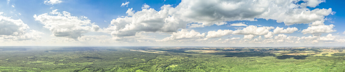 Fototapeta na wymiar countryside landscape in sunny summer day under cloudy blue sky. panoramic aerial photo