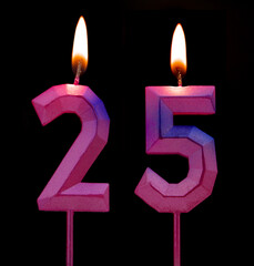 Burning birthday candles isolated on black background, number 25