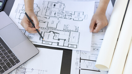 Architectural building design and construction plans with blueprints, Young man was designing a...