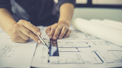 Engineer and Architect concept, Man uses a ruler to measure the floor plan on the blueprint,...