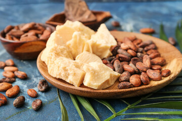 Composition with cocoa butter, beans and chocolate on color background, closeup