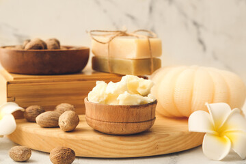 Fototapeta na wymiar Shea butter, nuts and bath supplies on light background, closeup