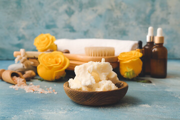 Composition with shea butter, bath supplies and flowers on color background