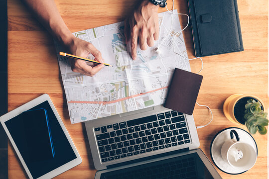 Tourist planning vacation use pen pointing on the map and other travel accessories around on the table. Vocation, travel, holidays and backpack concept. - Powered by Adobe