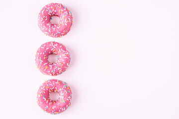set of pink donut sprinkle on pink background. copy space