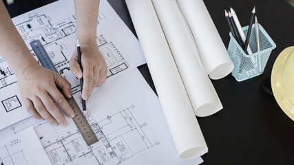 Engineer and Architect concept, Man uses a ruler to measure the floor plan on the blueprint,...