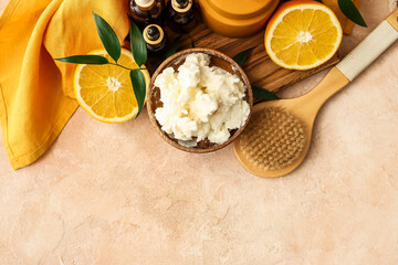 Composition with shea butter, orange fruits, brush and cosmetic products on color background