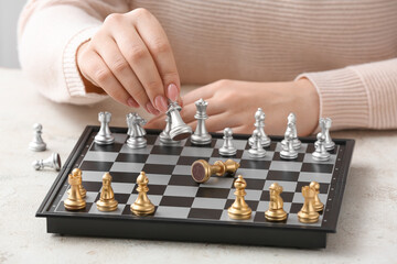 Woman playing chess on light table