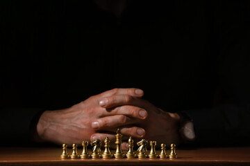 Man playing chess on dark background, closeup